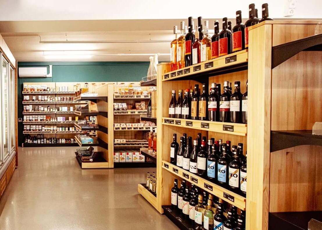 Wand- und Gondelregale für Weinpräsentation aus Holz und Metall. Regalsystem UNIVERSAL HOLZ. Biosupermarkt in der Schweiz
